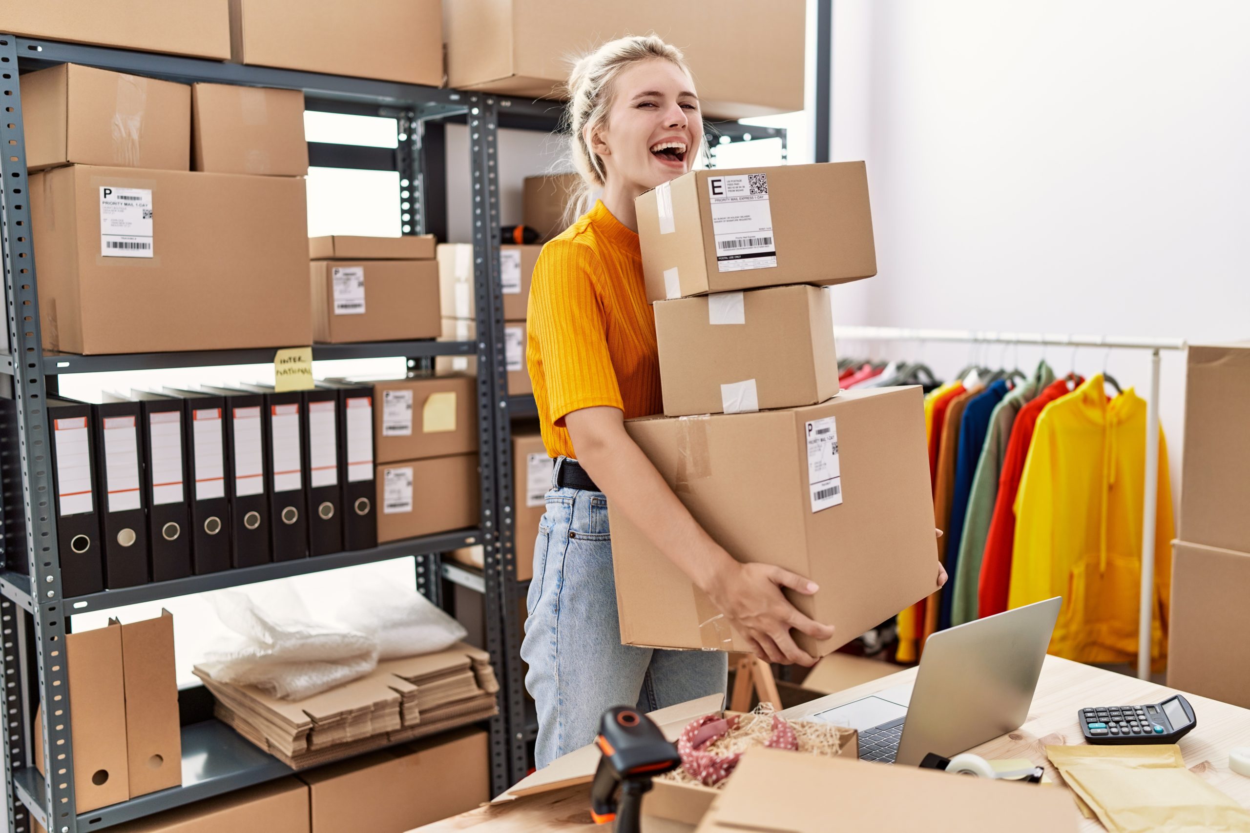 Young blonde woman working at small business ecommerce celebrating crazy and amazed for success with open eyes screaming excited.